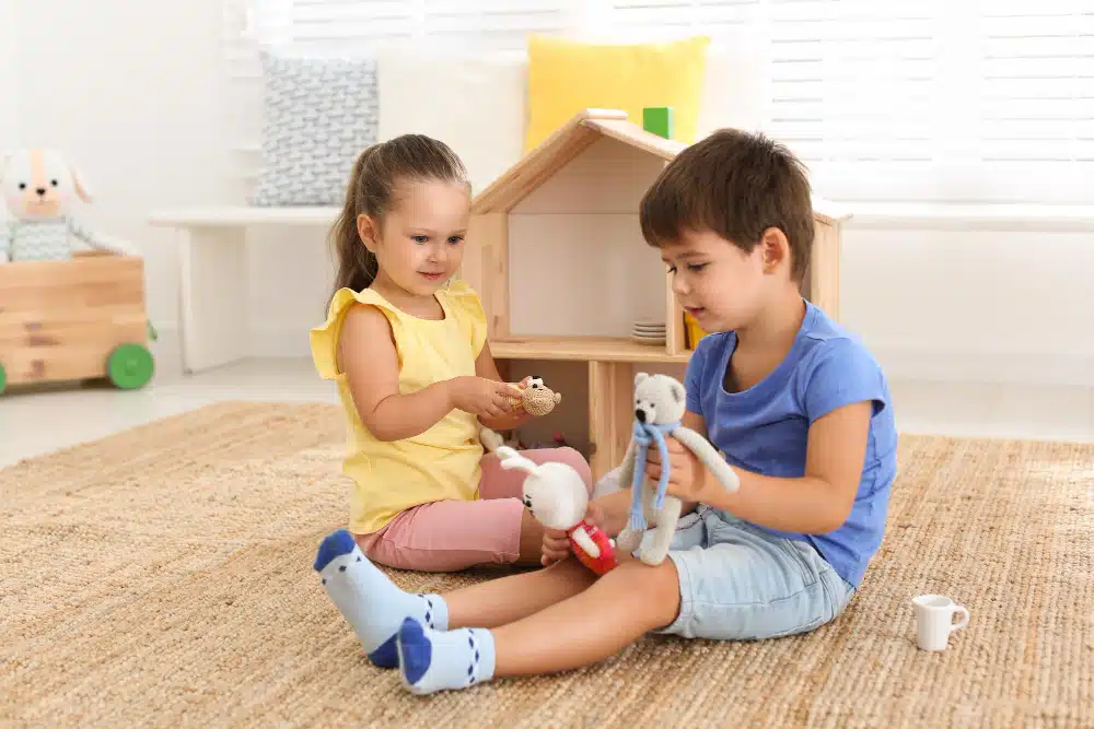 Um menino e uma menina brincando juntos de casinha, representando a importância de brincar sem estereótipos.